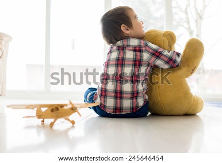 Portrait of child sitting in living room with Teddy bear