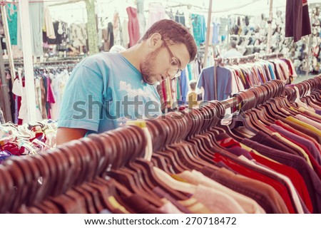 Young man buying in second hand store