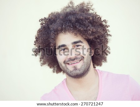 Portrait of young attractive guy with long curly hair