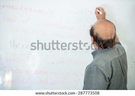 Senior chemistry professor giving a lecture in front of classroom