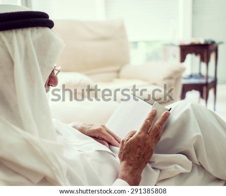 Elderly man sitting and reading book