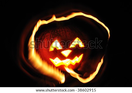 The carved face of pumpkin glowing on Halloween