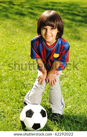 Cute little boy playing with a ball in beautiful park in nature
