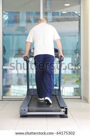 Elderly bald man running in gym