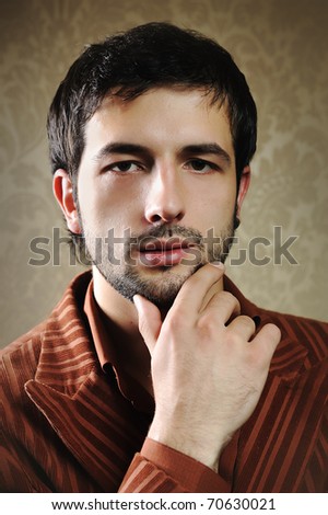 Young fashionable stylish man with a short beard posing