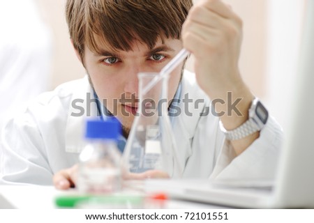 Young medical scientist working in modern lab, research with tubes and notebook