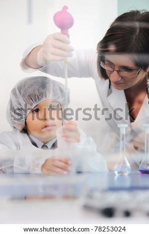 Smart cute little male child  experimenting in lab with his mother doctor scientist