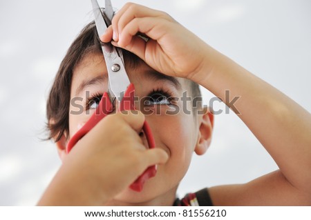 Kid cutting hair to himself with scissors, funny look