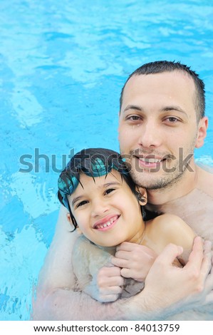 Father and son in pool, summertime