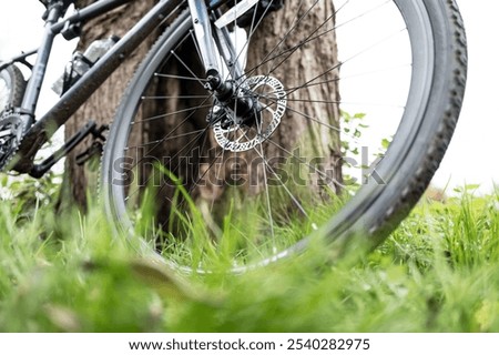 Similar – Foto Bild Mountainbiker aufgestützt auf Fahrradlenker blickt in die Ferne.