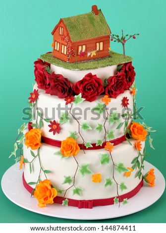 Nice wedding cake with sugar flowers and little house on top