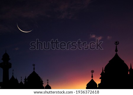 Crescent moon sky on dark blue dusk over Islamic mosque silhouette,Twilight Sky in the Evening with Sunset and Beautiful Sunlight on dark cloud ,Hari raya festival,Eid al-Adha, Eid al-Fitr, Muharram.