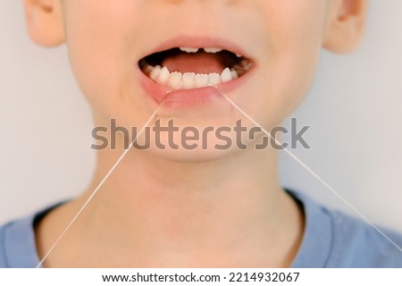 Similar – Image, Stock Photo Child flossing face and tiring milk tooth to pull out