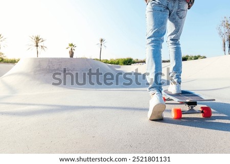 Image, Stock Photo Relaxed stylish skater riding skateboard along pavement