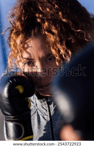 Similar – Image, Stock Photo Serious sportswoman with boxer braids posing with crossed arms