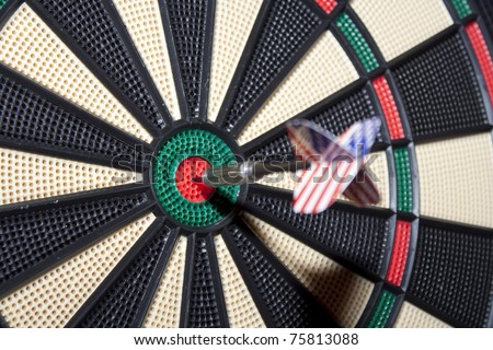 Business Success Concept - A dart with a USA flag just smacked in the center of the board. Focus on the board.
