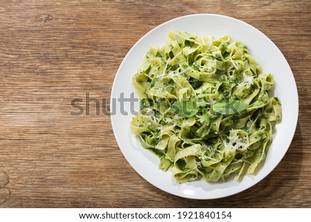 Similar – Image, Stock Photo Green tagliatelle pasta with ham, parmesan cheese, arugula and tomatoes on black plate