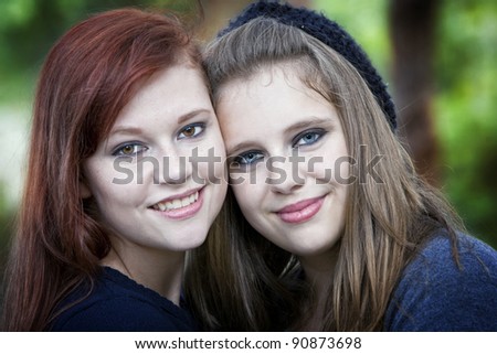 Beautiful blonde and redhead sisters together smiling