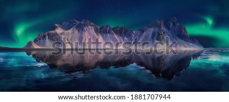 Vestrahorn mountaine on Stokksnes cape with Green northern lights and reflections. Amazing Iceland nature seascape.  Iconic location for landscape photographers and bloggers. Scenic Image of Iceland 商業照片 © 