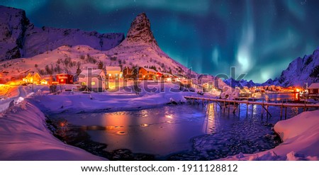 Wonderful winter scenery. popular touristic destination Reine. colorful night scene with Green northern lights above mountains Lofoten Islands. One of the most wonderfull nature sightseeing in Norway.