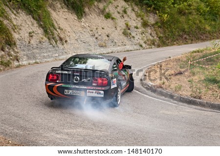 DOVADOLA, ITALY - JULY 28: the crew Errani - Folci on a drift racing car Ford Mustang in action with smoking tires in hairpin bend at Rally della Romagna 2013, on July 28, 2013 in Dovadola, FC, Italy
