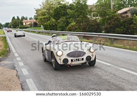 RAVENNA, ITALY - MAY 17: unidentified crew on a vintage sports car Austin Healey 100 S (1955) in rally Mille Miglia 2013, the italian historical race (1927-1957) on May 17, 2013 in Ravenna, Italy
