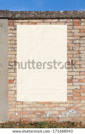 blank street advertising billboard glued on brick wall - empty white poster,sheet of paper, copy space