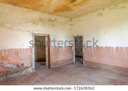 empty room of an abandoned house - old dirty hall in ruins with peeling wall