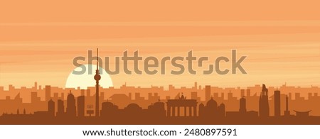 Brown panoramic poster of the city skyline with misty background buildings, sunrise, clouds and mountains of BERLIN, GERMANY