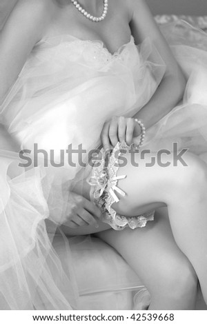 A bride putting on her wedding garter
