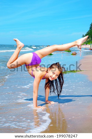 Happy little sporty girl on beach