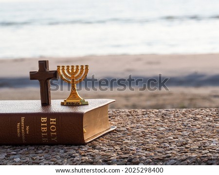 Red heart with wooden Christian cross on gravel floor in morning light, beach sea as background. Jesus love you. Faith hope believe in God. Believe in salvation. Christianity background concept. Foto stock © 