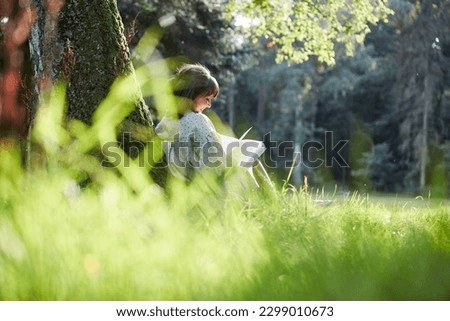 Similar – Foto Bild Junge Frau liest ein Buch am Strand liegend