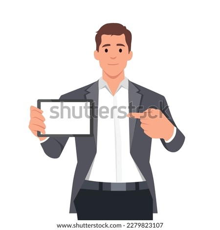 Happy confident business man showing a blank screen tablet computer and pointing towards it. Business man standing isolated in white background holding empty screen tablet PC. 