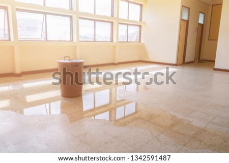 water leak drop interior office building in red bucket from Ceiling and flow on terrazzo floor Stok fotoğraf © 