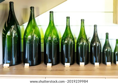 Different types of green glass champagne sparkling wine bottles from smallest to biggest i n museum Stock fotó © 