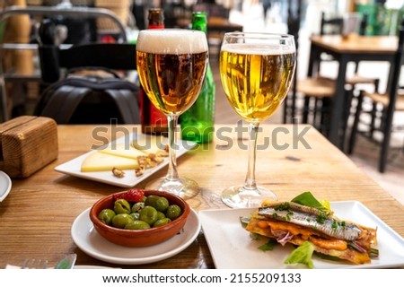 Lunch with cold beer in Spanish outdoor cafe, different tapas, green olives and Spanish cheese manchego with nuts, Malaga, Andalusia Foto stock © 