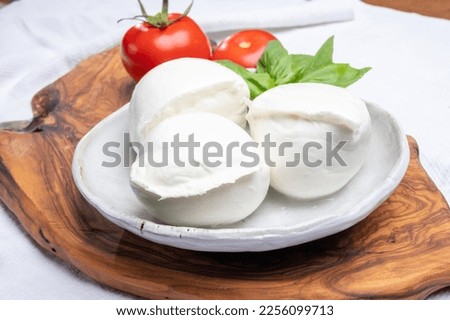 White balls of Italian soft cheese Mozzarella di Bufala Campana served with fresh green basil leaves and red tomato Stok fotoğraf © 