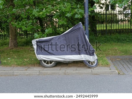 Similar – Image, Stock Photo Waterproof cover for motorcycle with silver reflective protective surface. Motorcycle covered with fabric shield and parked outside