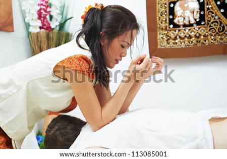 Traditional thai massage health care procedure, kneading back and shoulders muscules of man