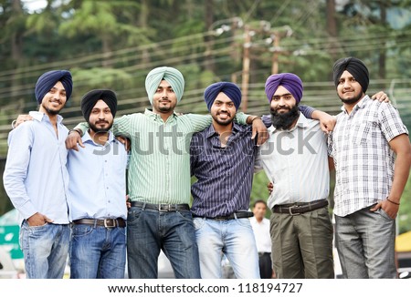 Group portrait of smiling authentic native indian punjabi sikh men in turban with bushy beard