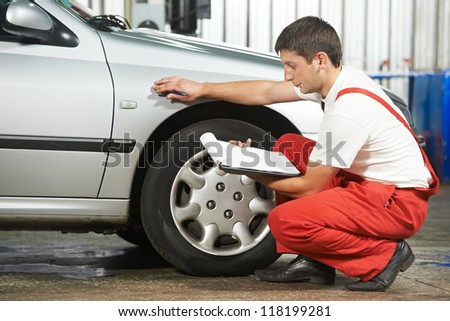 mechanic repairman inspecting car body during automobile car maintenance at auto repair shop service station