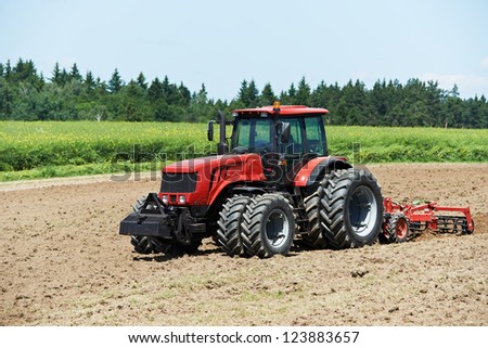 Ploughing heavy tractor during cultivation agriculture works at field with plough