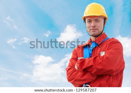 Construction site manager worker in uniform and safety protective equipment over blue sky