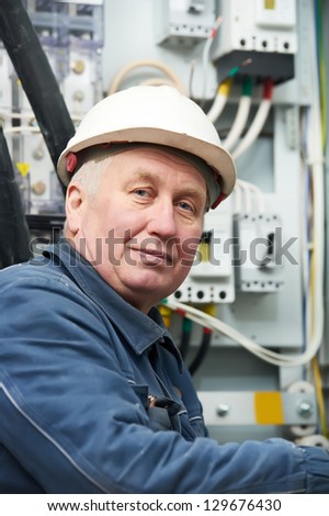 Adult senior electrician portrait at work in front of electrical fusion housing box