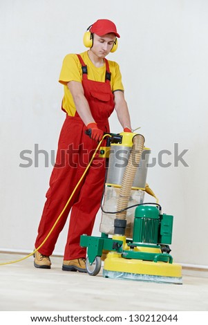 carpenter doing parquet Wood Floor polishing maintenance work by grinding machine