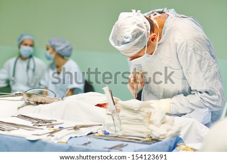 surgeon perform operation on a patient at heart surgery clinic