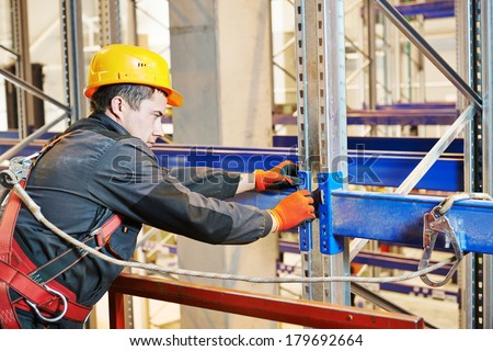 One warehouse worker in uniform during rack erection work installation