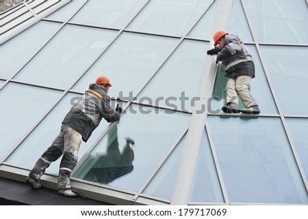 Two male industrial builders workers at outdoors window installation