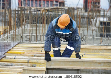 construction worker at construction site assembling falsework for concrete pouring
